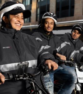 delivery men on e-bikes smiling
